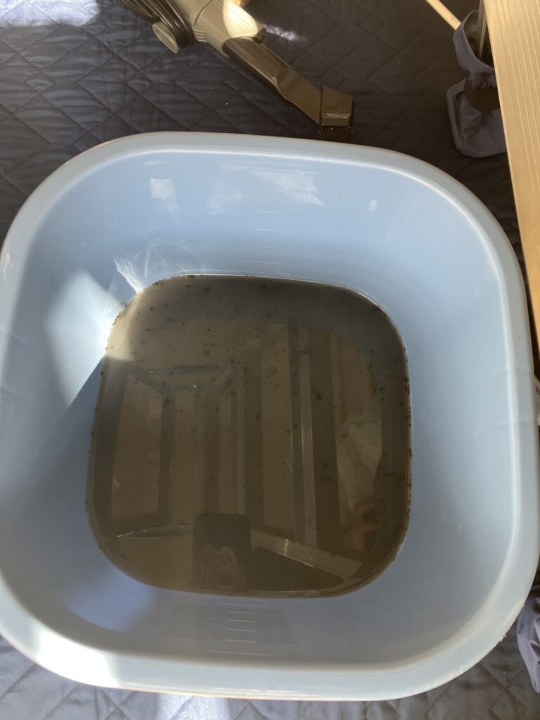 エアコンクリーニングの高圧洗浄機で発生した黒い汚水の写真。