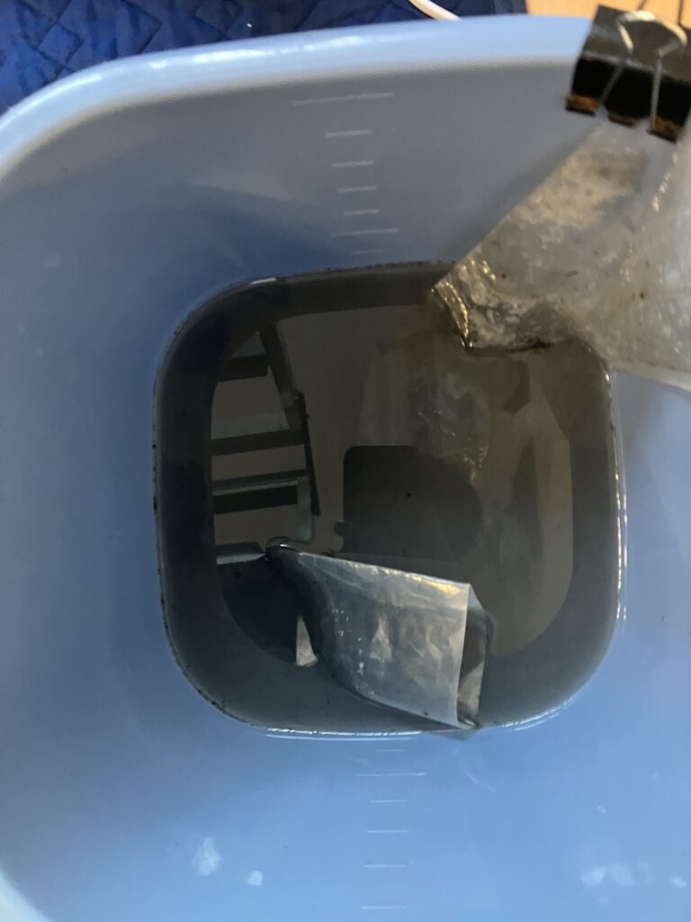 エアコン内部洗浄で回収された黒いカビ汚れとホコリが溶け出した汚水