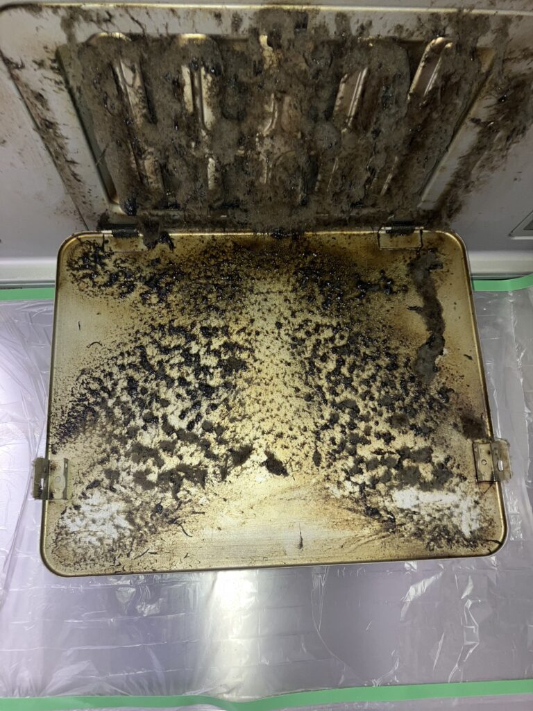 練馬区の換気扇クリーニング作業前｜油汚れで真っ黒になったレンジフード内部パネル